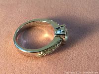 Close-up photo of the silver rhodium-plated ring showing detail of crystal arrangement and band inside size marking 925