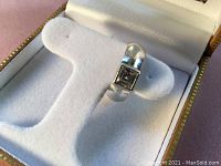 Vintage 925 sterling silver ring with a square-cut black stone presented on white cushioned insert.