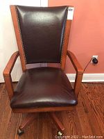 Front view of the Bombay executive desk chair showing dark brown leather seat and back with nailhead trim and wood frame.