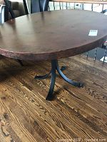 Full view of round copper top and iron base