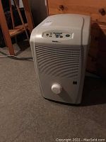 Photo of standing white Danby Designer dehumidifier unit showing front and top part with control panel and vent grille.