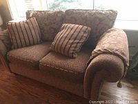 Front angle of Decor-Rest loveseat showing upholstery and decorative pillows