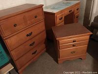 Overall view of wooden dresser with four drawers and matching bedside table with three drawers, showing their design and finish.