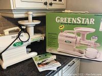 Juicer assembled next to original box and manual on countertop