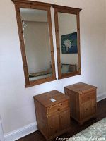 View of two solid pine night tables and two matching solid pine framed mirrors on a wall.
