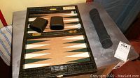 Open croc-embossed case showing backgammon board interior, storage trays with chips, dice, doubling cube and dice cups, travel set tube visible at right