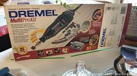 Photo of original boxed Dremel MultiPro kit showing rotary tool and accessories count with box branding.