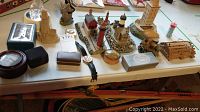 Image showing multiple handcrafted miniature lighthouses, watches, figurines, and nautical knickknacks on a table.