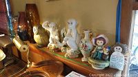 Two white ceramic monkey figurines from Abigail’s Italy, ceramic garden solar light owl, five glass vases on shelf