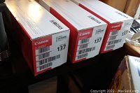 Three boxed Canon 137 toner cartridges stacked side by side showing brand, model and packaging condition.