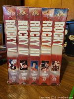 Front view of the unopened VHS box showing spines of all five Rocky movies labeled Rocky I to Rocky V with original artwork.