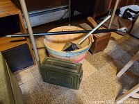 Full view of lot showing walking stick, mess kit bucket, shoeshine box, ammo box, reacher and flashlight on floor.