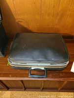 Closed black carrying case of Signature 440 portable typewriter, showing exterior condition and handle.