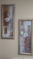 Pair of framed flower prints side by side showing overall appearance and size on beige wall