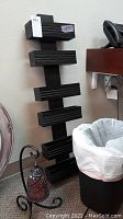 Mosaic lamp on black wrought metal stand, black wall hanging magazine rack, and white waste basket shown together, highlighting size and details.