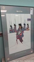 Framed mounted print showing Native American women in traditional dress holding a pot, with grey mat and glass, front view.
