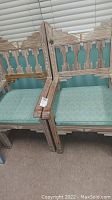 Two photos showing two Aztec style wooden arm chairs placed side by side, featuring geometric carved backs and armrests with light green padded seats.