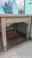 Full view of light tone distressed wood square Aztec style side table.