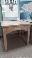 Side view of the wooden side table showing square legs and distressed light tone finish in Aztec style.