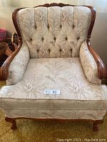Front facing view of the armchair showing overall upholstery and wood frame.