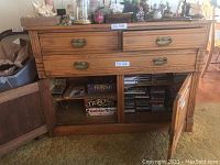 Frontal view showing three drawers with ornate brass handles above two cabinet doors with keys in locks. The wood grain and finish are well visible.