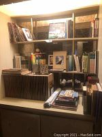 Wide view of shelves containing multiple books including Time Life Library of Art volumes and other assorted books, magazines, and maps.