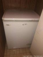 Closed view of white Danby chest freezer with minor exterior wear.