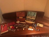 Group shot showing three wooden boxes, two-tier case, valet tray and assorted jewelry and accessories on wooden surface
