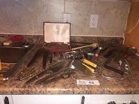Wide view of kitchen countertop with various kitchen utensils and the steak knife set in original case in background