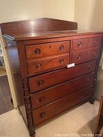 Front view of large solid wood dresser with six drawers and round wood pulls.