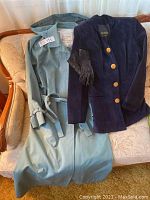 Full view of London Fog trench coat, Danier blazer, and black leather gloves placed on a couch.