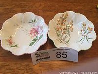 Two Shelley China trinket dishes displayed side by side on wooden surface, showing both floral patterns and scalloped edges