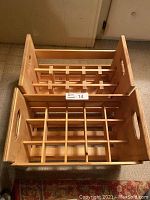 Top view of two wooden wine crates showing internal wooden grid compartment dividers and cut-out handles.