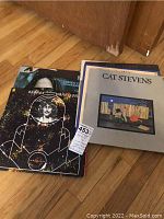 View of seven vinyl LP records showing George Harrison album in front with distinct space-themed black cover.