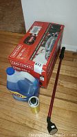 Boxed Craftsman automotive pressure washer with spray wand and cleaning fluid placed on wooden floor.