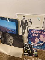 Overview of multiple items including framed art, posters, and books grouped together.