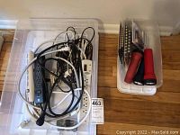 Photo of the plastic tote containing various power cords and power strips