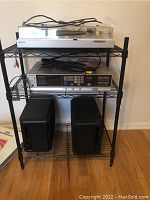 Three-tier metal stand holding Sony turntable (top), Sony tuner (middle), Bose speakers (bottom)
