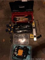 Overview of toolbox filled with hand tools, clamps, saw, level, and plastic organizer