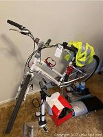 Full view of white Specialized Sport women’s bike with accessories piled beneath