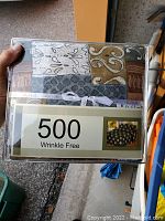 Photo showing front side of packaged king sheet set with multicolor patchwork design, indicating wrinkle free 500 thread count.