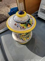 Photo of a ceramic cookie jar showing colorful hand-painted designs and the word 'CARAMEL' on the front.