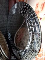 Front view of a round mirror with a reflective mosaic tile frame showing its design and finish.