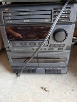 Front view of JVC Compact Component Stereo System MX-GX7 showing control panel, CD changer slots, cassette deck, volume knob, and antenna wire.