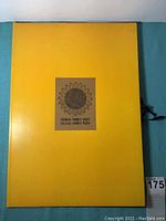 Yellow portfolio folder with label sunflower image and text 'Yokohama Woodcut Prints Nagasaki Woodcut Prints'
