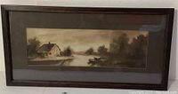 Full view of the framed landscape print showing the cottage, water, and boat in sepia tones.