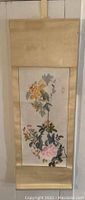 Full view of the Japanese floral scroll painting mounted on beige backing, hanging on wall.