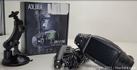 Photo showing the HD car DVR unit with dual lenses, original packaging box, suction cup mount, and power adapter cable.
