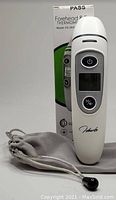 Forehead and ear thermometer with digital display, model FC-IR1T, shown with original box and gray pouch.