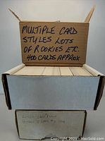 Two white and brown cardboard boxes containing approximately 400 mixed style rookie sports cards.